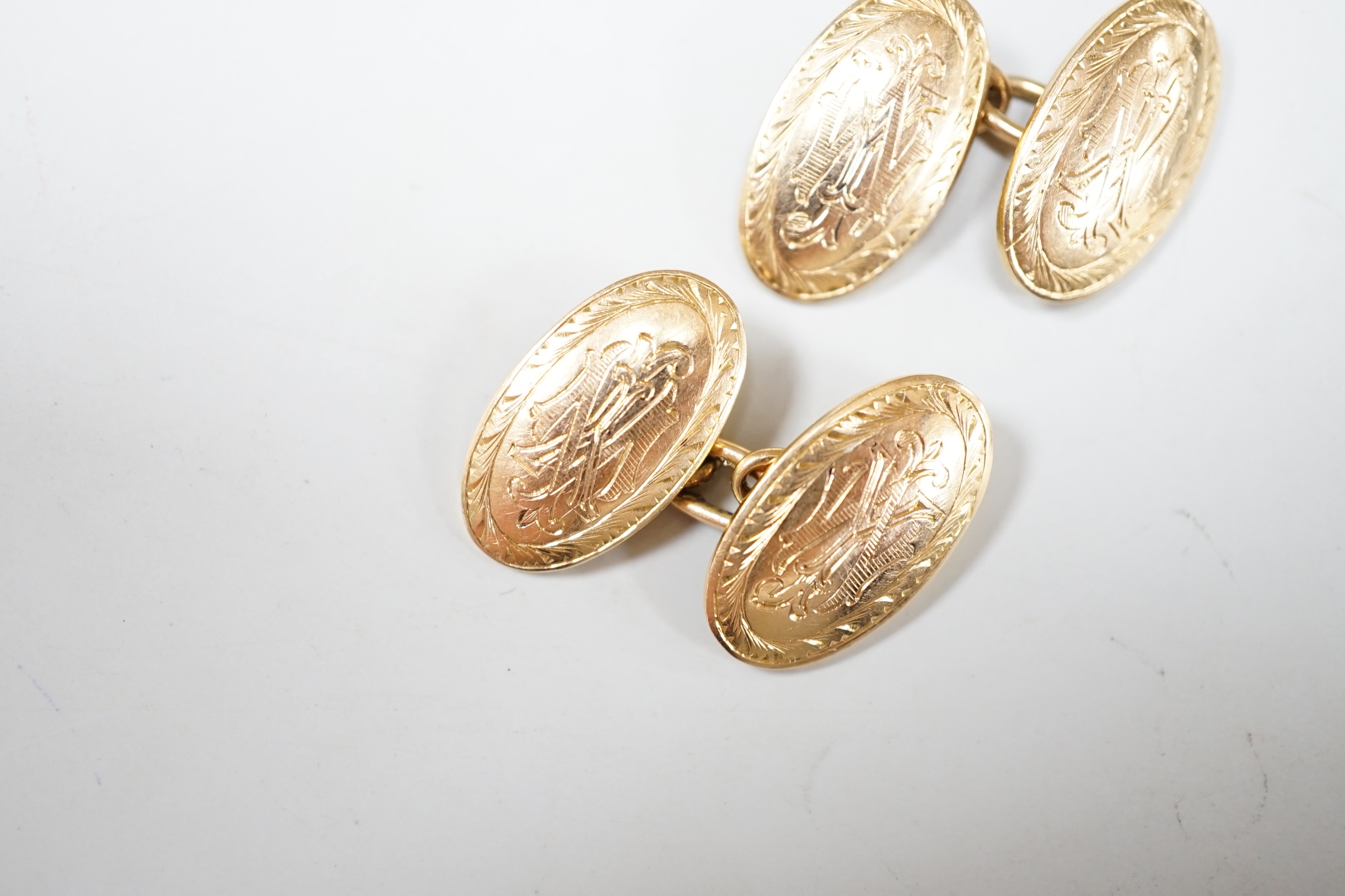 A pair of Edwardian engraved 15ct gold oval cufflinks, 10 grams.